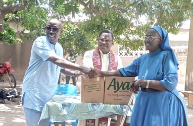   Thaddeus Sory (left) presenting the items to Sister Gabriel Nonaah at the ceremony